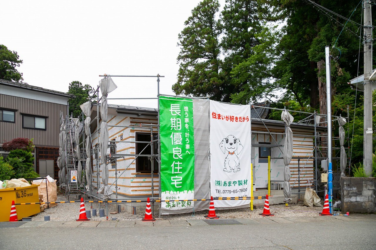 長期優良住宅の懸垂幕がかかった平屋の建築現場の外観